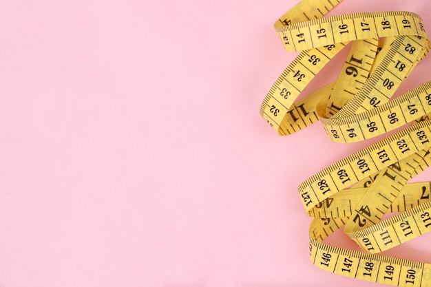 Photo tape measure for obese people on a pink background soft focus