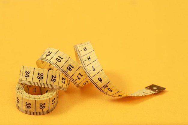 Photo tape measure for obese people on a yellow background soft focus