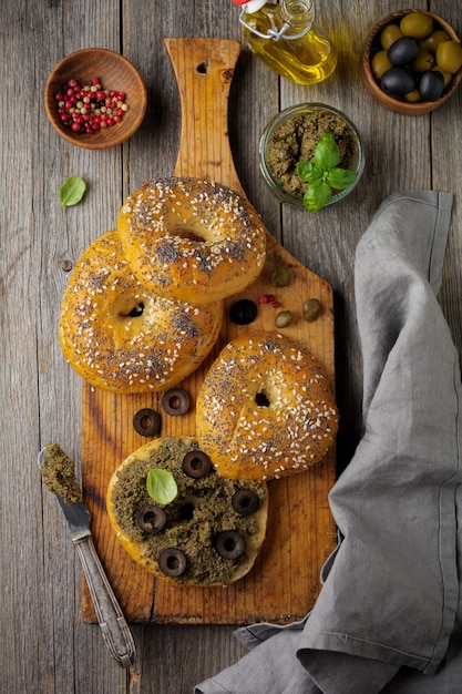 タプナード、黒と緑のオリーブ、バジル、古い木製のテーブルの上のパンと伝統的なプロヴァンス料理