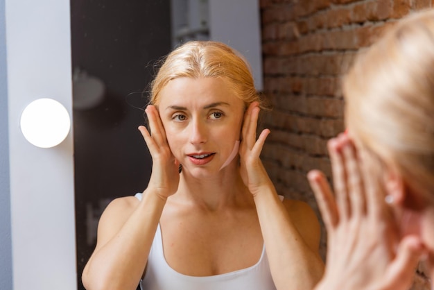 Foto taping con nastro kinesiologico per il sollevamento dei muscoli facciali e l'effetto di ringiovanimento