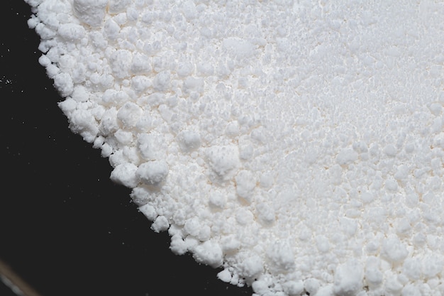 Photo tapioca flour in a frying pan in closeup photo and top view