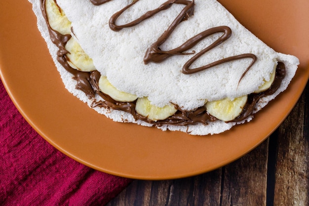 Tapioca, typical of northeastern Brazil, banana with chocolate and hazelnut cream. Selective focus.