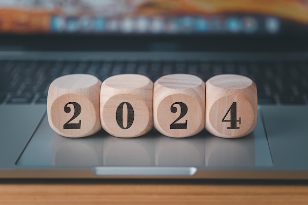 Target bedrijfskosten en budgetplanning en houten kubus met jaartal 2024 en doelpictogram op stapel