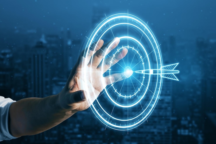Photo target concept with a glowing hologram of bullseye and arrow hitting the center goals achievement success close up of businessman hand using hud screen on blurry night city background