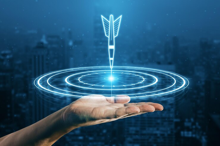 Photo target concept with a glowing hologram of bullseye and arrow hitting the center goals achievement success close up of man hand using hud screen on blurry night city background