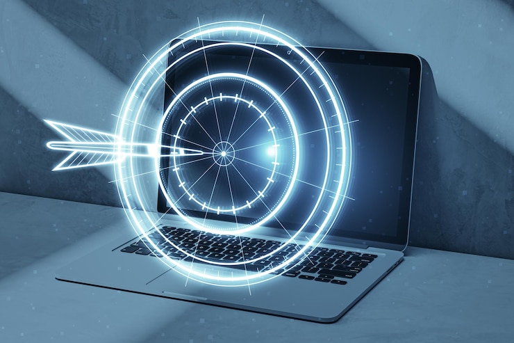 Photo target concept with a glowing hologram of bullseye and arrow hitting the center growth strategy goals achievement success close up of laptop on blurry workplace background double exposure