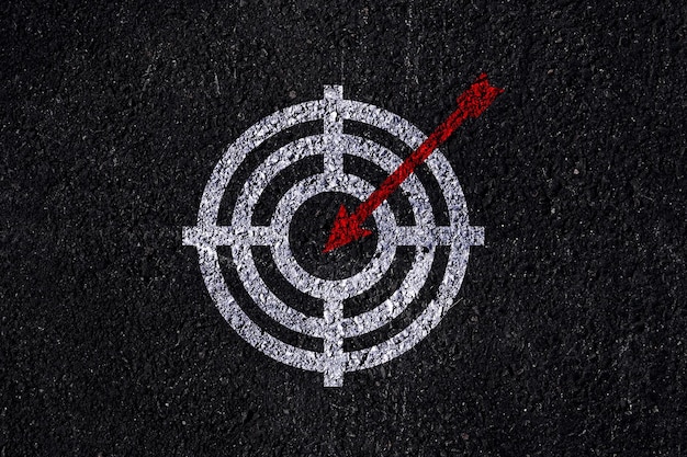 Target figure on dark wall concept of achieving goal quality Aim Target Red Symbols of goals and objectives over dark wall background Business idea