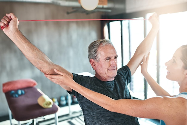 Targeting arm strength with resistance bands Shot of a senior man using resistance bands with the help of a physical therapist