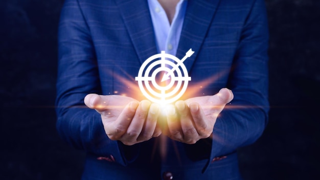 Targeting concept with businessman hand holding digital image of dartboardBusinessman holding virtual dartboard and arrow with copy space for setup business objective target concept