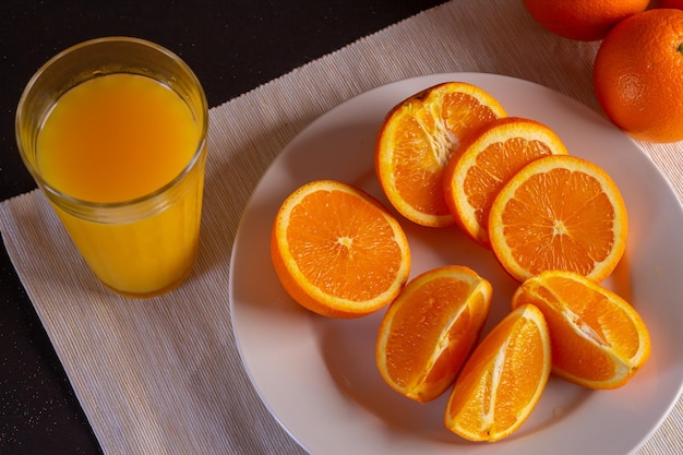 Tarro de cristal con zumo de naranja fresco en fruta fresca sobre una mesa, vista cercana.