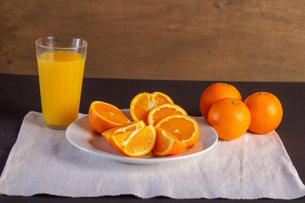 Tarro de cristal con zumo de naranja fresco y fruta fresca sobre una mesa