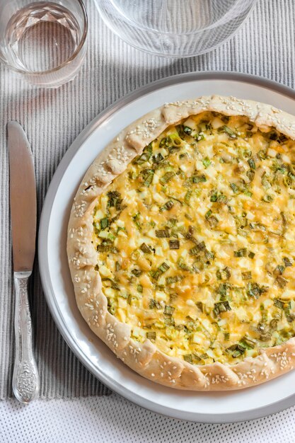 Tart with eggs and green onions on a plate