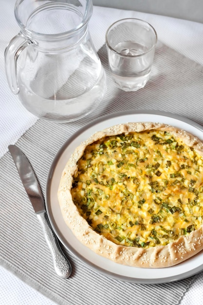 Tart with eggs and green onions on a plate