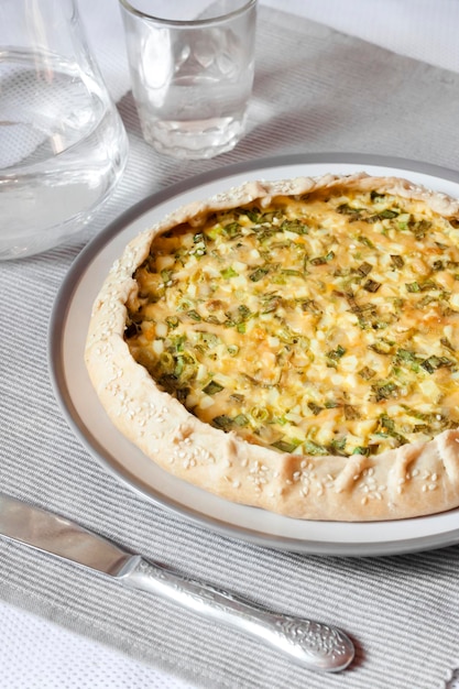 Tart with eggs and green onions on a plate