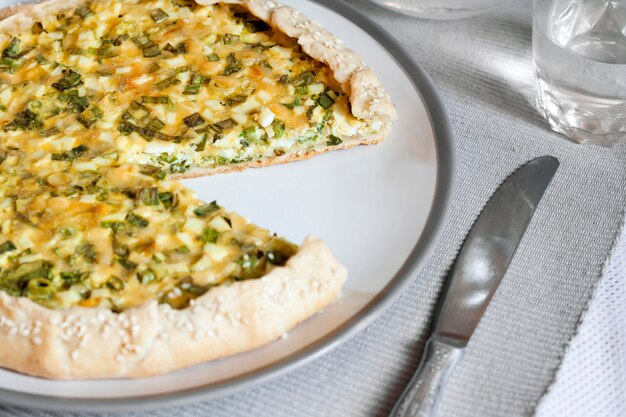 Tart with eggs and green onions on a plate