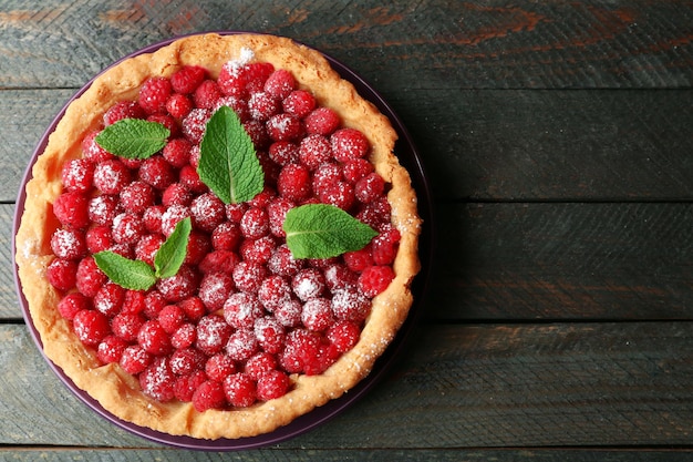 tart with fresh raspberries on wooden background