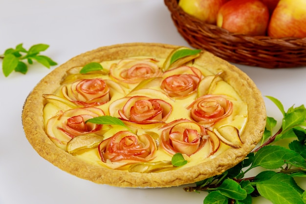 Tart with rose shape apple decorated and fresh apples. Top view.