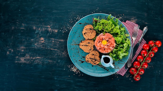 Tartaar met zalm en avocado Op een houten ondergrond Bovenaanzicht Kopieer de ruimte