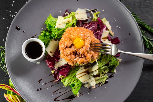 A Tartar dish on black wooden baclground