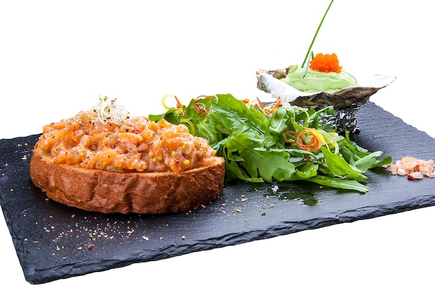 Tartar of salmon on toast on the stone and a white background