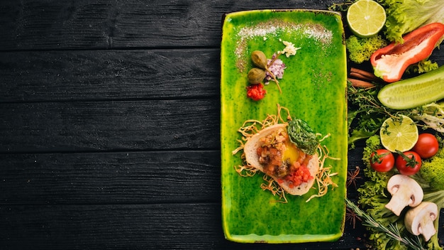 Tartar salmon with quail egg Cold snacks On a black wooden background Copy space