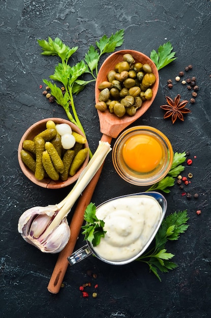 Tartar sauce Making sauce from capers cucumbers parsley lemon and eggs Top view free space for your text