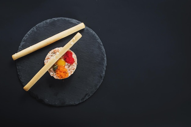 Tartar with caviar and bread sticks on black