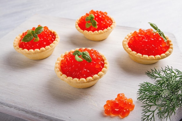 Tartlets met rode kaviaar op een lichte achtergrond close-up bovenaanzicht geen mensen