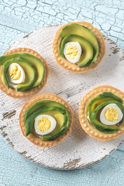 Crostatine con crema di formaggio, avocado e uova di quaglia