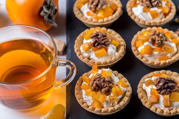 Tartlets with curd cream, persimmon and tea