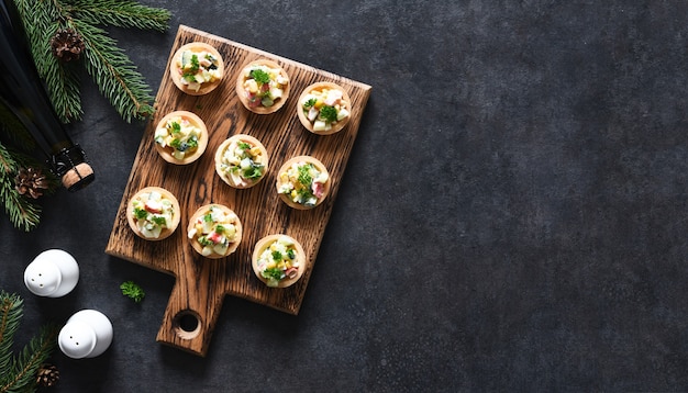 Tartlets with salad and champagne on the New Year's table. View from above.