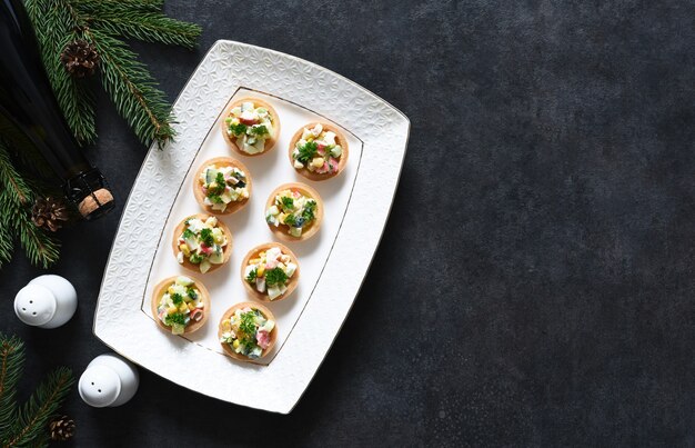 Tartlets with salad and champagne on the New Year's table. View from above.