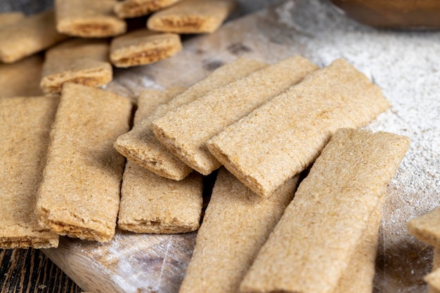 Tarwe lange koekjes gevuld met gepureerde verschillende fruitkoekjes met fruitvulling op tafel met bloem