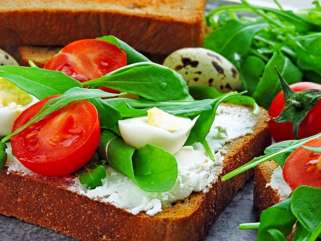 Tarwe Roggebroodjes met rucola, kwarteleitjes en kerstomaatjes.