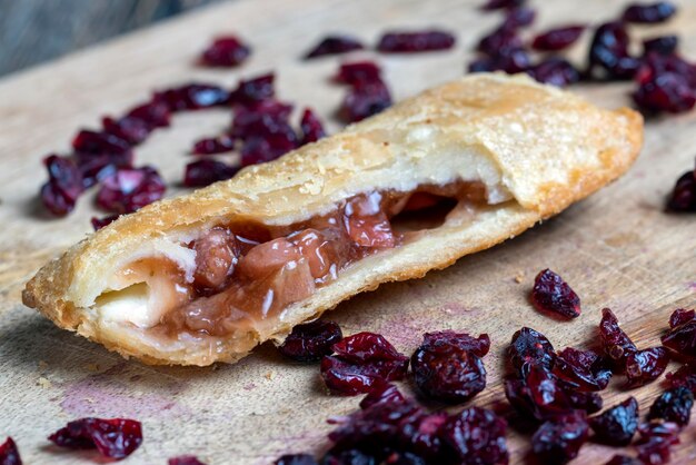 Tarwegebakjes met rode kersen-aardbeienvulling op een bord gedroogde veenbessen gedroogd in zoete siroop liggen rond het bakken