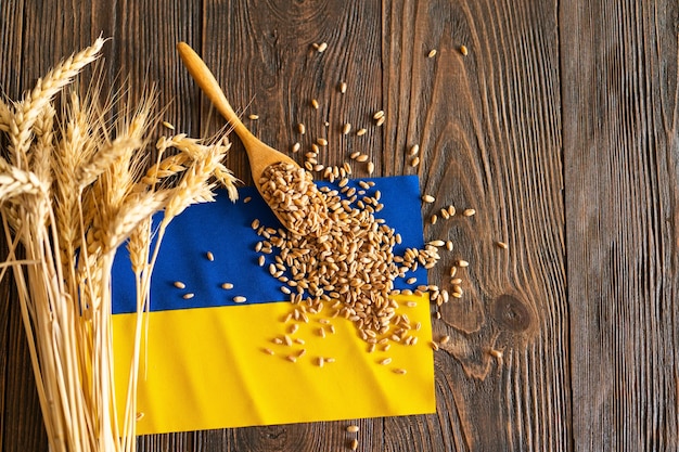 Tarwegranen met een gele en blauwe Oekraïense vlag op een houten achtergrond