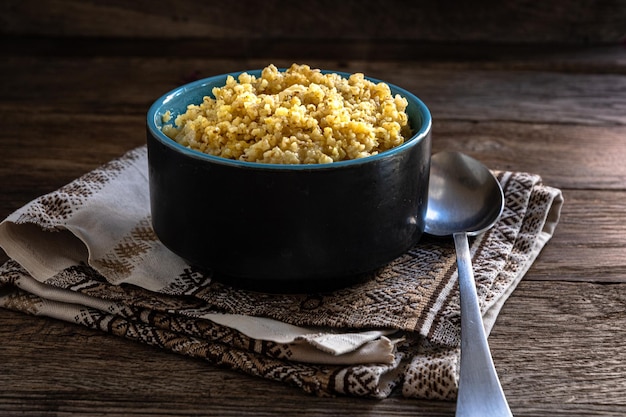 Tarwepap in een keramische kom en een lepel op een houten tafel Zelfgemaakt eten