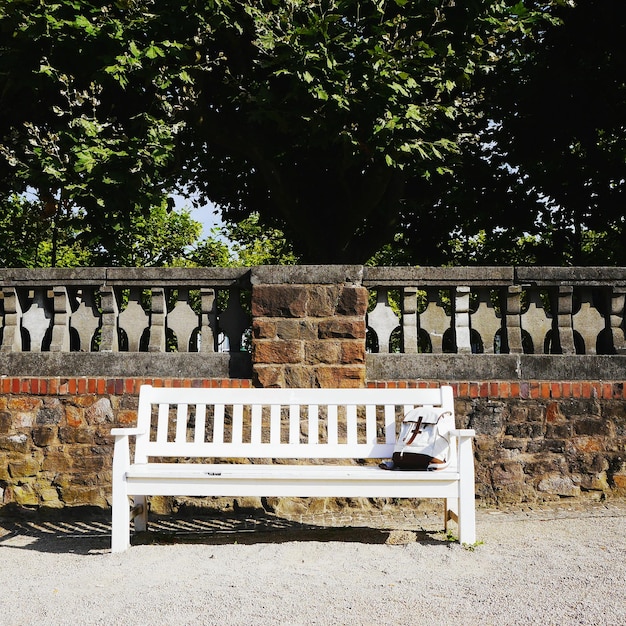 Foto tas op een houten bank tegen de omringende muur