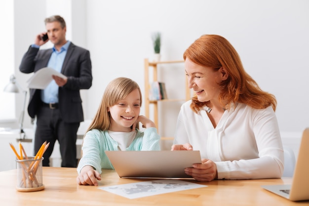 Task to teach. Gorgeous hardworking energetic lady taking her daughter in the office