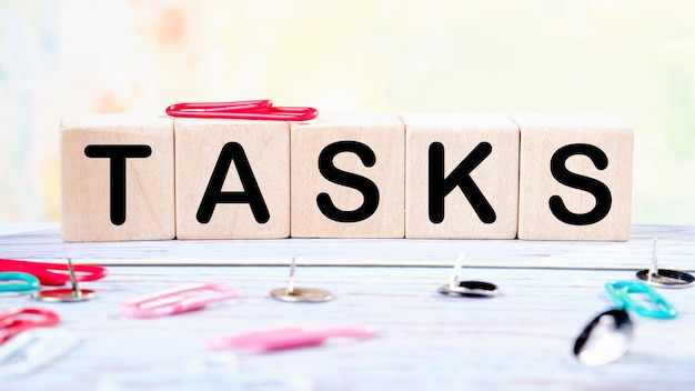 Tasks text written on wooden cubes on a light colored\
background
