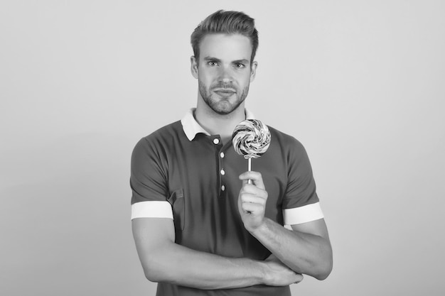 Taste the rainbow man candy yellow background handsome guy hold
candy on stick candy shop lollipop or sucker sugary treat candy
factory and confectionary