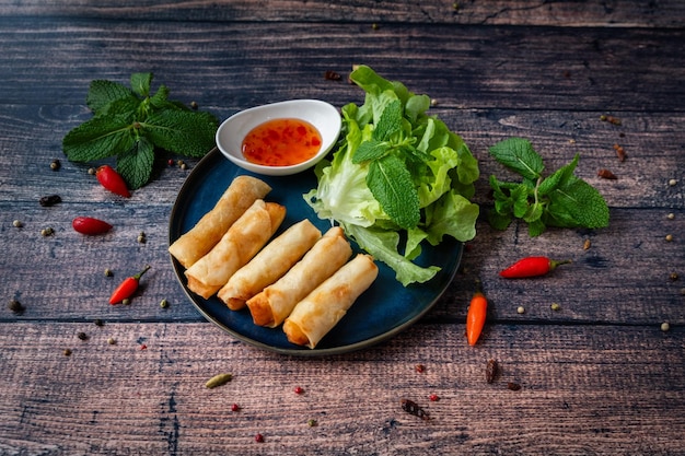 Foto cibo orientale fresco e gustoso nems su un piatto con salsa e gustose foglie di menta fresca