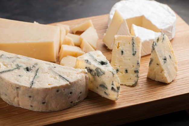 Tasting cheese dish on a wooden plate.