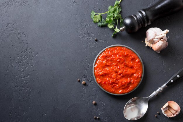 Tasty ajvar on toast Vegetable sauce or caviar of baked red bell pepper on black Balkan cuisine Space for text Top view