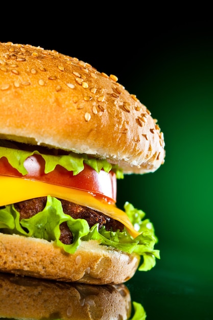 Tasty and appetizing hamburger on a darkly green background