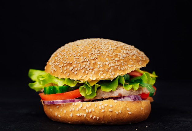 맛있고 식욕을 돋우는 햄버거. 블랙에 고립 된 신선한 맛있어 햄버거