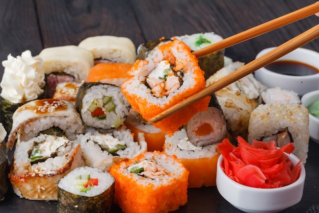 Tasty appetizing multicolored sushi rolls set, served with soy sauce and chopsticks