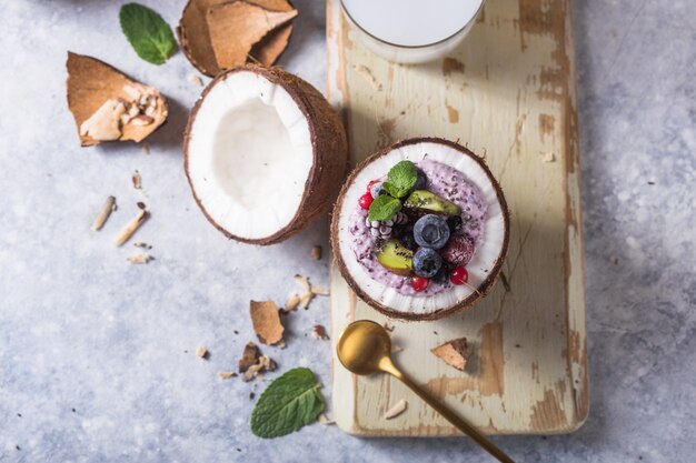 Ciotola di acai frullato appetitoso gustoso a base di more e frutti di bosco. servito in una ciotola di cocco. concetto di cibo pulito vita sana. bella crema da dessert surgelata.