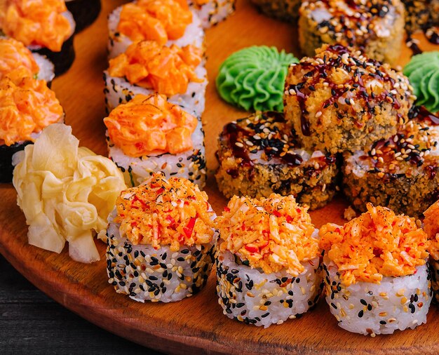 Tasty appetizing sushi rolls set on wooden board