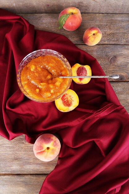 Photo tasty apricot jam with fresh apricots on wooden table